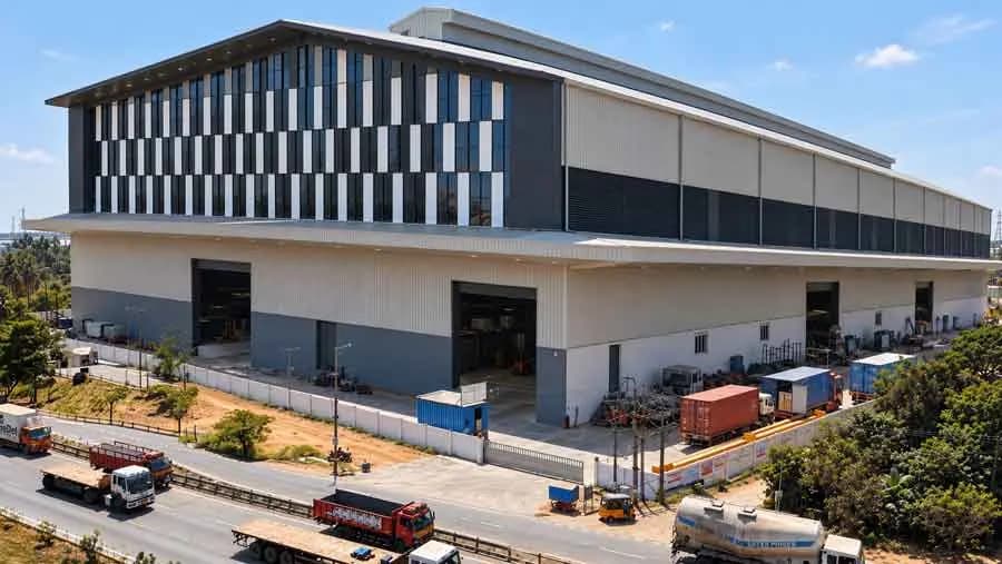 Modern industrial building with a louvred facade and loading yard